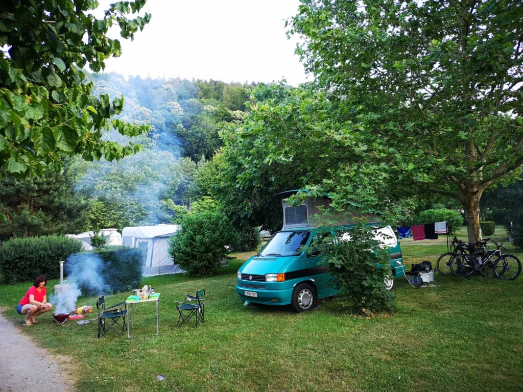 Emplacement ombragé avec van et tente au camping